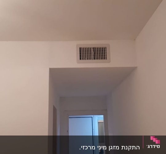 פתח אוורור של מזגן בתקרה לבנה
